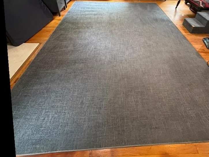 The same gray area rug after deep extraction, evenly clean with the watermark rings gone